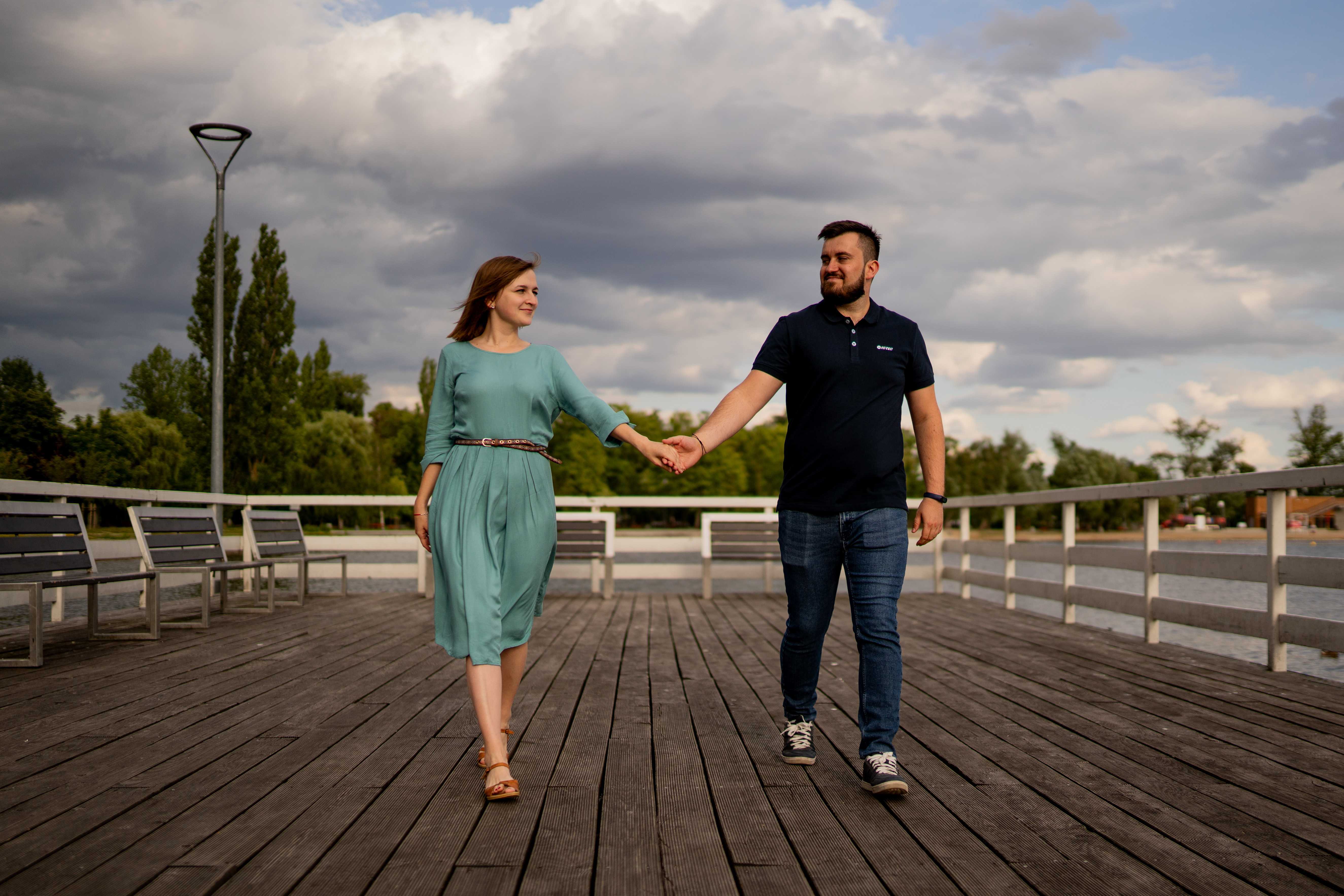 Narzeczeni obejmujący się na tle malowniczego krajobrazu, pełni miłości i spokoju.