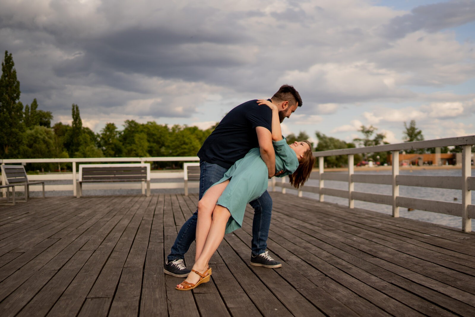 Narzeczeni obejmujący się na tle malowniczego krajobrazu, pełni miłości i spokoju.