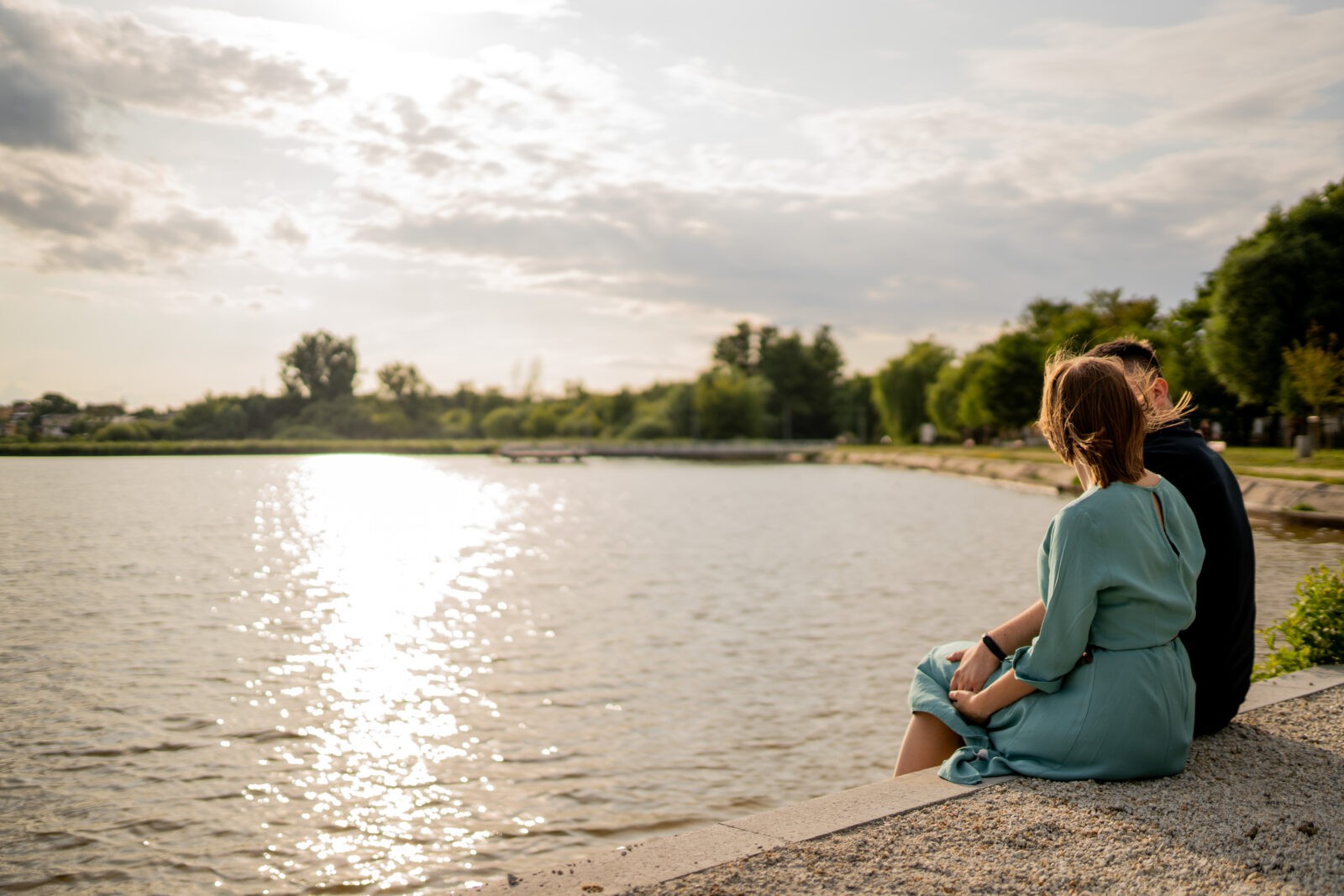 Narzeczeni obejmujący się na tle malowniczego krajobrazu, pełni miłości i spokoju.