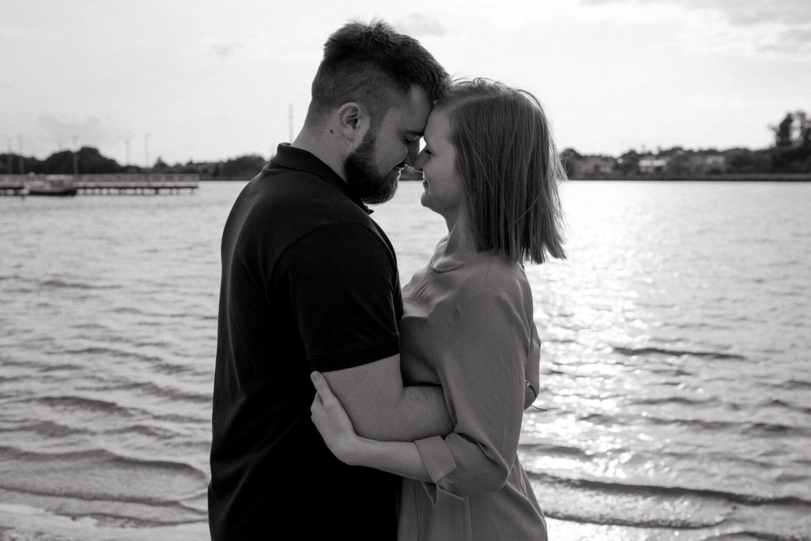 Narzeczeni obejmujący się na tle malowniczego krajobrazu, pełni miłości i spokoju.