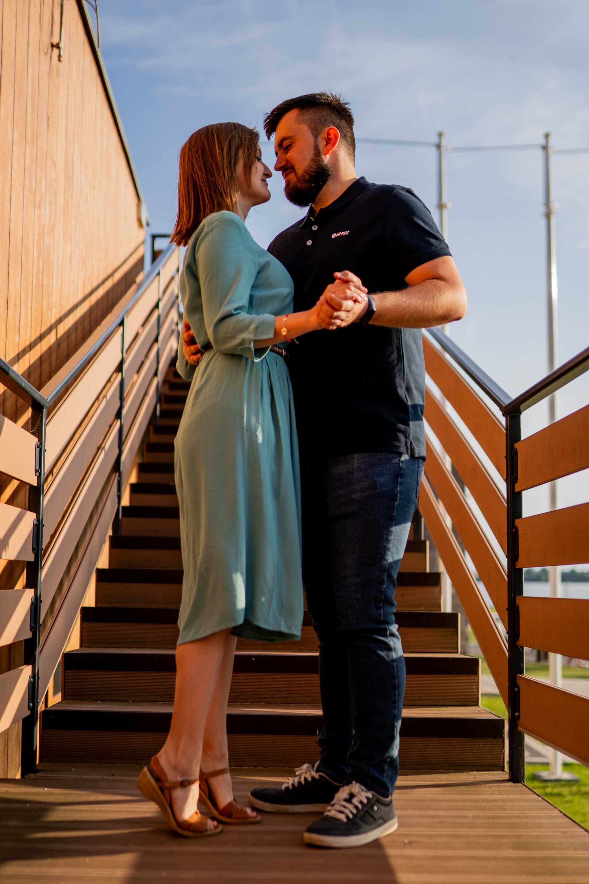 Narzeczeni obejmujący się na tle malowniczego krajobrazu, pełni miłości i spokoju.