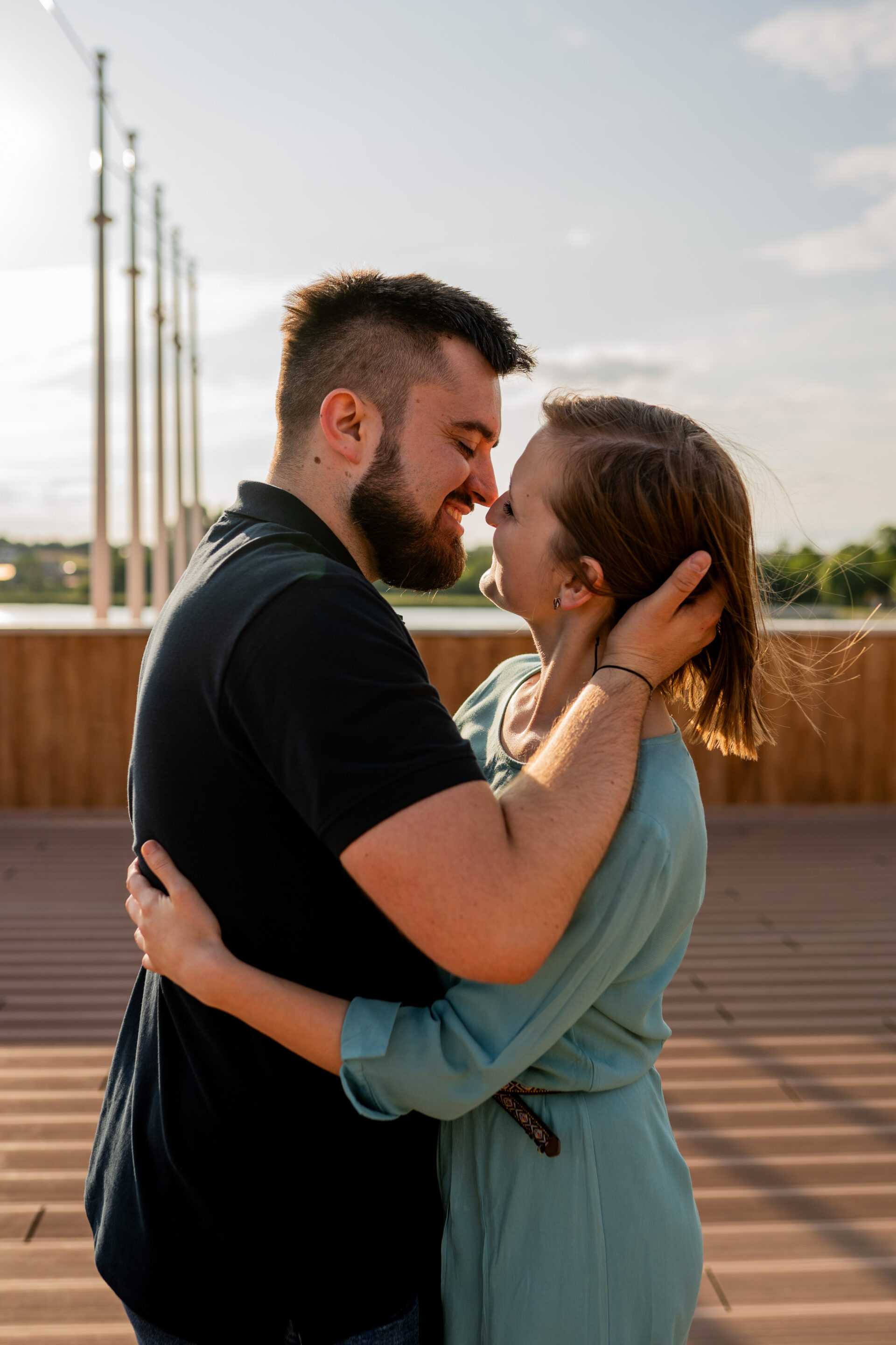 Narzeczeni obejmujący się na tle malowniczego krajobrazu, pełni miłości i spokoju.